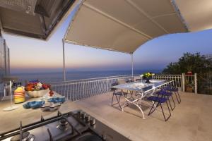 a patio with a table and chairs on a balcony at AMORE RENTALS - Villa Domus Franca in Massa Lubrense