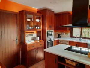 a kitchen with wooden cabinets and a white counter top at Villatrajín in Otura