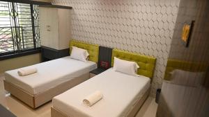 a room with two beds in a room with at Hotel Maisha International in Sonāmura