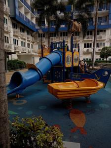 um escorrega azul num parque infantil em frente a um edifício em King of kings em Manila