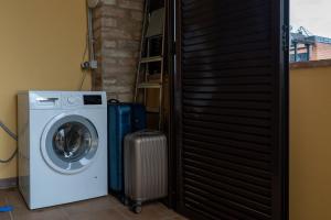 een wasmachine en een koffer naast een deur bij Casale Corciano in Ellera