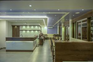 a restaurant with a bar with tables and chairs at Hotel Limelight in Kudal