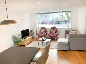 sala de estar con sofá, mesa y sillas en Bright, spacious, 3-bedroom Emirates apartment with terrace, en Londres