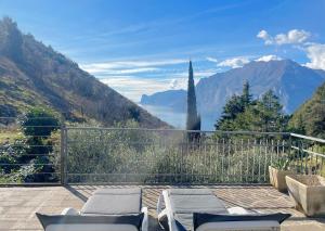 a balcony with chairs and a view of mountains at ViewLake Apartment in Nago-Torbole