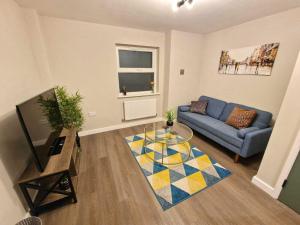 ein Wohnzimmer mit einem Sofa und einem Tisch in der Unterkunft Vere Apartments in Cardiff