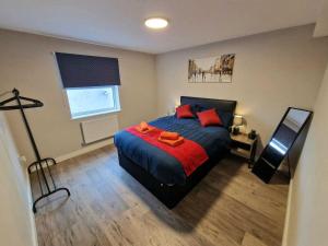 1 dormitorio con 1 cama grande con almohadas rojas en Vere Apartments en Cardiff