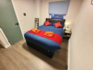 1 dormitorio con 1 cama grande con almohadas de color naranja en Vere Apartments en Cardiff