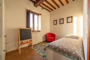 een slaapkamer met een bed, een tv en een stoel bij Casale Corciano in Ellera