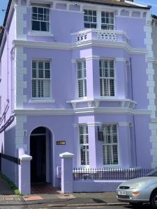 una casa púrpura con un coche aparcado delante de ella en Gyves House en Eastbourne