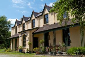 a large house with many windows and potted plants at Over the Rainbow - Vegetarian Guesthouse in Blaenporth