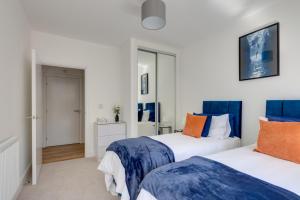 Stevenage Luxury 1 Bed Apartment Sleeps 4 WIFI Free Parking Secure by JM Short Lets في ستيفنيج: غرفة نوم بسريرين ومرآة