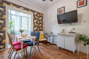 a living room with a table and chairs and a tv at Classy apartment in Sofia