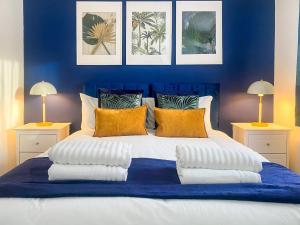 a blue bedroom with a large bed with pillows at Phoenix House - 2 Double Bedroom House - Business and Corporate Travellers in Luton