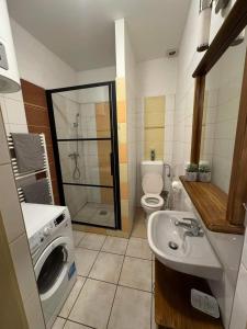 a bathroom with a sink and a washing machine at Kahwa Apartments in Budapest