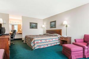 a hotel room with a bed and a chair at BlissPoint Inn Wabash in Wabash