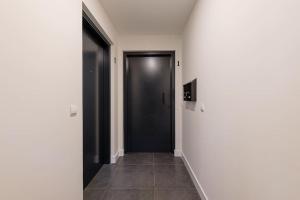 einen Flur mit schwarzer Tür und Fliesenboden in der Unterkunft Hermoso estudio en Legazpi °2 in Madrid