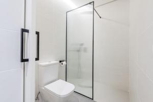 ein Bad mit einem WC und einer Glasdusche in der Unterkunft Hermoso estudio en Legazpi °2 in Madrid