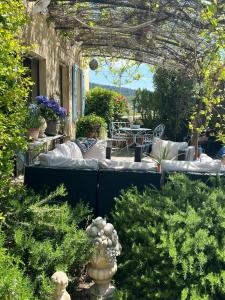 - un jardin avec un lit, une table et des chaises dans l'établissement L'EPICURE- Zimmer Marsanne, à Vacqueyras