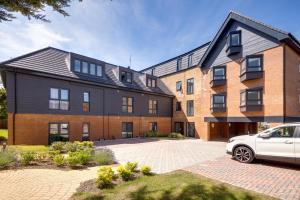a building with a car parked in front of it at Stevenage Luxury 1 Bed Apartment Sleeps 4 WIFI Free Parking Secure by JM Short Lets in Stevenage