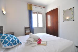 ロザスにあるRNET - Sant Pau Rosesのベッドルーム1室(白いベッド1台、タオル付)、窓が備わります。