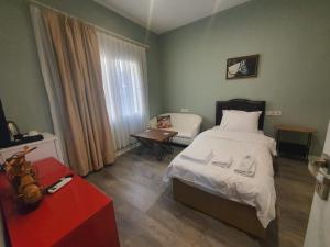 a bedroom with a bed and a chair and a table at st945 Palas Otel in İzmir