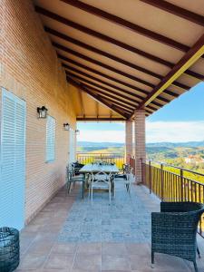 eine Terrasse mit einem Tisch und Stühlen auf dem Balkon in der Unterkunft La Encina, casa tranquila con excelentes vistas in Mesones