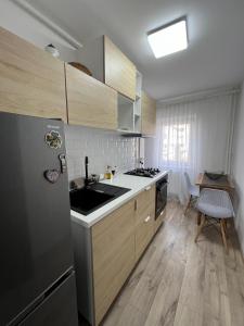a kitchen with a stainless steel refrigerator and a table at Bianca's Place in Piteşti