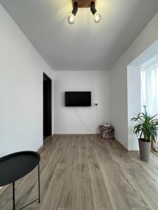 an empty living room with white walls and a flat screen tv at Bianca's Place in Piteşti