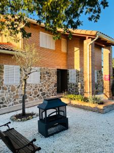 a bench and a table in front of a building at La Encina, casa tranquila con excelentes vistas in Mesones