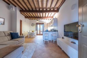 een woonkamer met een bank en een keuken bij Casale Corciano in Ellera