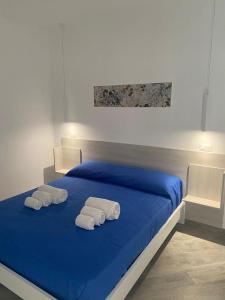 a bedroom with a blue bed with towels on it at B&b Villa Jasmine in Palinuro