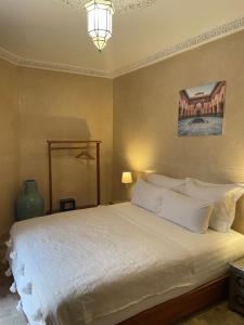a bedroom with a large bed with white pillows at Riad Amalia in Marrakech