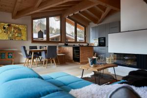 a living room with a blue couch and a table at Wetterstein-Chalet in Leutasch