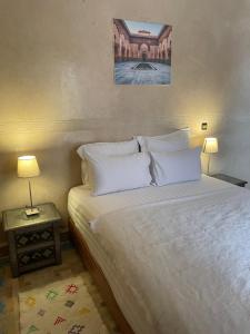 a bedroom with a bed with white sheets and pillows at Riad Amalia in Marrakech
