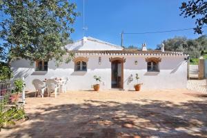 a white house with chairs and a patio at Casa da Maria Teresa V2 in Santa Catarina da Fonte do Bispo