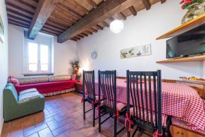 ein Wohnzimmer mit einem Tisch, Stühlen und einem Sofa in der Unterkunft Ca' Maggetti in Urbino