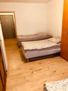 three beds in a room with wooden floors at Pension Stein bei nürnberg in Stein