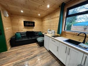 uma cozinha e sala de estar num chalé de madeira em The Secret Garden - Hot Tub North Coast Stay em Garvagh