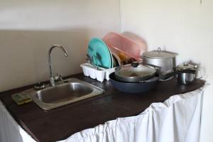 eine Küchentheke mit Spüle und einigen Töpfen und Pfannen in der Unterkunft Nabitunich in San Ignacio
