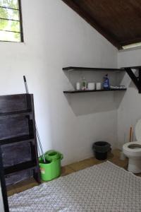 a bathroom with a toilet and a green bucket at Nabitunich in San Ignacio