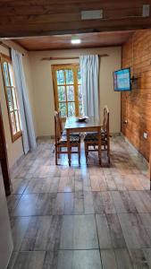 a dining room with a wooden table and chairs at Cabaña potrerillos La Tabaida in Potrerillos