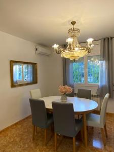 a dining room with a table and chairs and a chandelier at Casa Ricarda in Miami Platja