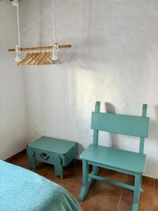 einen blauen Stuhl und einen Stuhl in einem Zimmer in der Unterkunft Casa Juan Harina in Setenil de las Bodegas