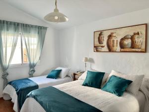 2 Betten in einem blau-weißen Zimmer in der Unterkunft Casa Juan Harina in Setenil de las Bodegas