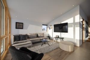 a living room with a couch and a flat screen tv at Kerbyggd: Luxury house and cottage in golden circle in Selfoss