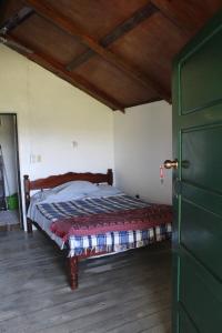 ein Schlafzimmer mit einem Bett und einer grünen Tür in der Unterkunft Nabitunich in San Ignacio