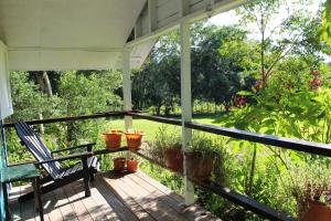 eine Veranda mit einem Stuhl und Topfpflanzen darauf in der Unterkunft Nabitunich in San Ignacio