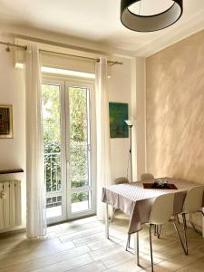uma sala de jantar com uma mesa e cadeiras e uma janela em Lovely 2 room apartment with small garden em Milão