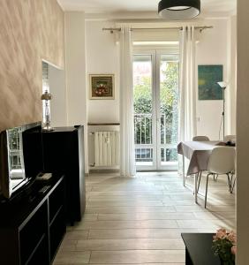 uma sala de estar com uma mesa e uma sala de jantar em Lovely 2 room apartment with small garden em Milão