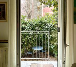 uma porta aberta com um portão com uma mesa no exterior em Lovely 2 room apartment with small garden em Milão